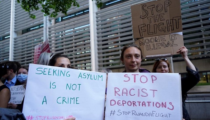 Protesters hold placards as they gather outside the Home Office in central London to demonstrate against the UK governments plan to deport asylum-seekers to Rwanda.—AFP