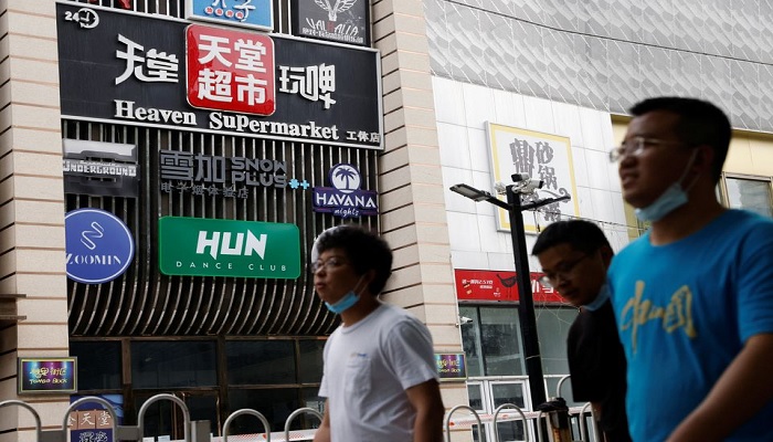 People walk past a sign of the Heaven Supermarket bar, where a coronavirus disease (COVID-19) outbreak emerged, in Chaoyang district of Beijing, China June 13, 2022.—Reuters