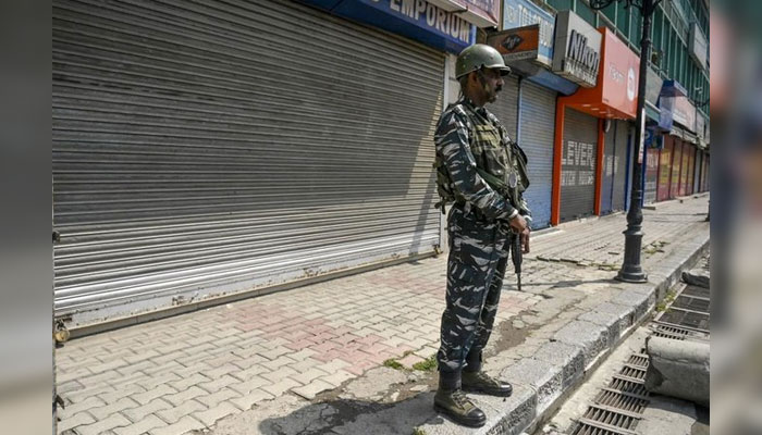 Above, an Indian paramilitary solider stands guard along a street in front of closed shops during a strike in Srinagar on June 10, 2022. — AFP