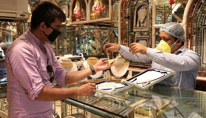 A gold dealer displays gold jewellery to a customer. — Reuters/File