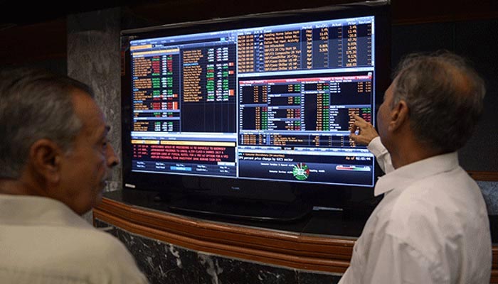 Investors can be seen looking at the stock list at PSX. — AFP/File