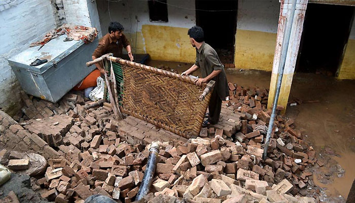 People collecting their belongings after a wall of their house collapsed due to rain in the Bara area. Photo — INP