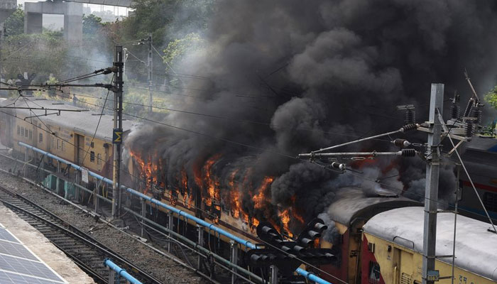 Smoke billows out from a passenger train coach after it was set on fire by protestors during a protest against Agnipath scheme for recruiting personnel for armed forces, in Secunderabad in the southern state of Andhra Pradesh, India, June 17, 2022. — Reuters