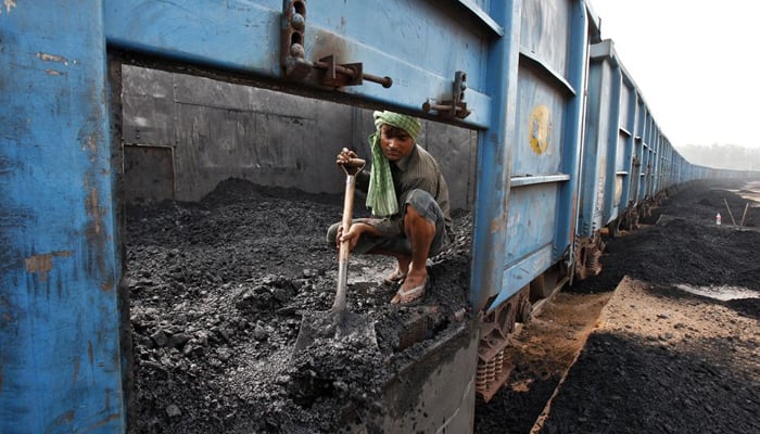 A worker unloads coal from goods train at a railway yard in the northern Indian city of Chandigarh July 8, 2014. — Reuters