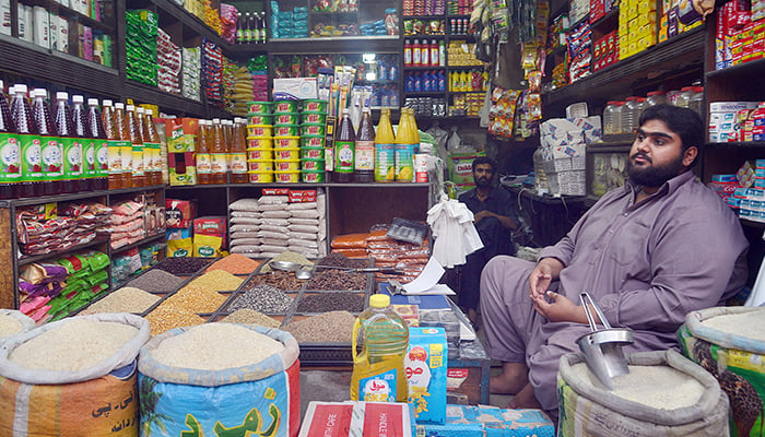 A shopkeeper waits for customers at his shop at a local bazaar in Lahore, June 13, 2022. — Online