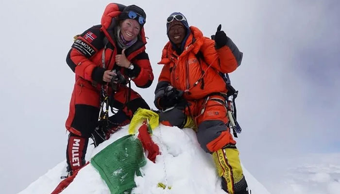 Kristin Harila avec un compagnon pose pour une photo au sommet d'une montagne enneigée.  — AFP/Fichier