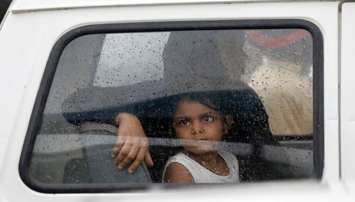 A girl looks out of a car window with raindrops during the seasons first monsoon rain in Karachi on July 6. 2020 — Reuters/File