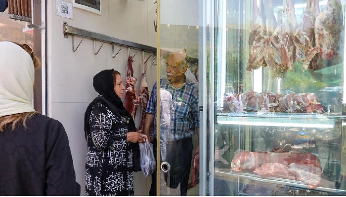 A woman shops at a butchers in Tehran.—AFP