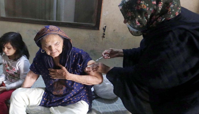 A healthcare worker can be seen giving a jab to an elderly woman in this file photo. — PPI/File