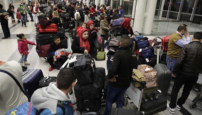 Syrian refugees with their luggage.—AFP