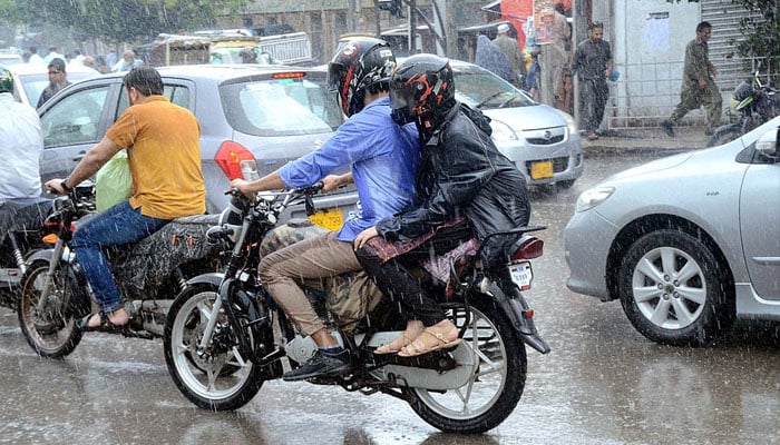 Motorcyclist on the way during rain that experienced the Provincial Capital. Photo —APP/Syed Abbas Mehdi