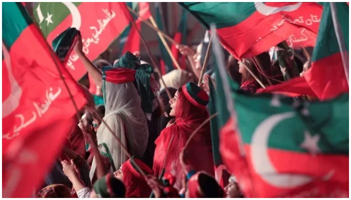 PTI supporters wave flags at a rally. — Reuters/File