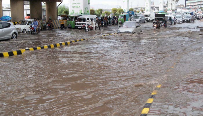 People facing difficulties due to accumulated rainwater at Marerr Chowk Road after the heavy rain in the morning hours in the city on June 20, 2022. — Online/File