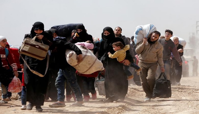 People walk with their belongings as they flee the rebel-held town of Hammouriyeh, in the village of Beit Sawa, eastern Ghouta, Syria March 15, 2018.—Reuters