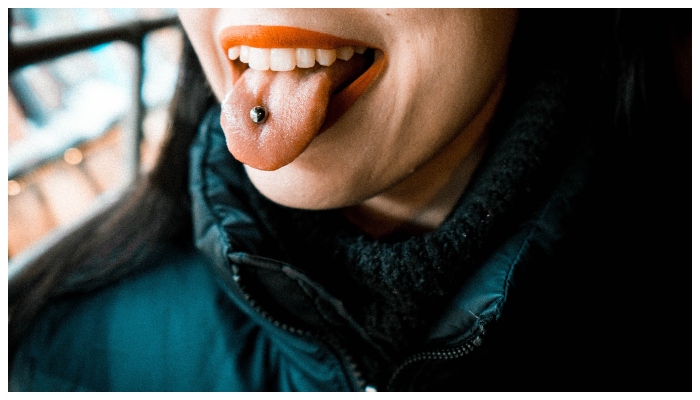 Image showing a person with a tongue piercing. —  Unsplash/ Lorenzo Nafissi