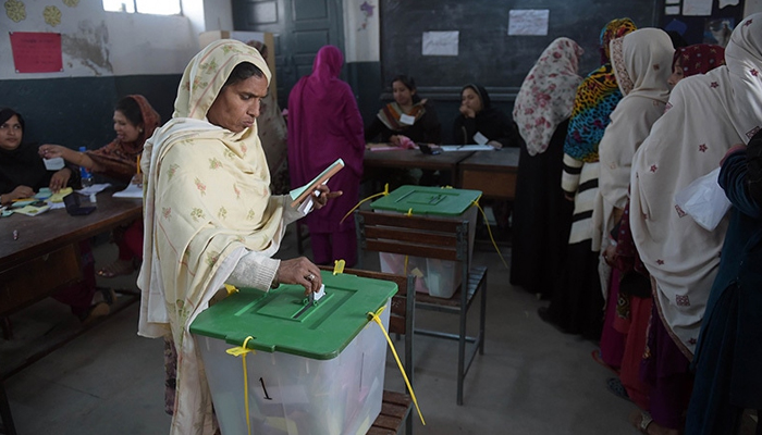 A voter casts her ballot at a polling station in Islamabad, on November 30, 2015. — AFP