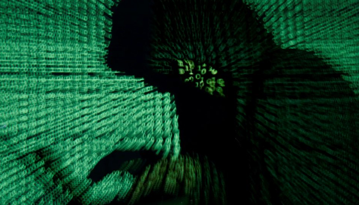 A man holds a laptop computer as cyber code is projected on him in this illustration picture taken on May 13, 2017. — Reuters