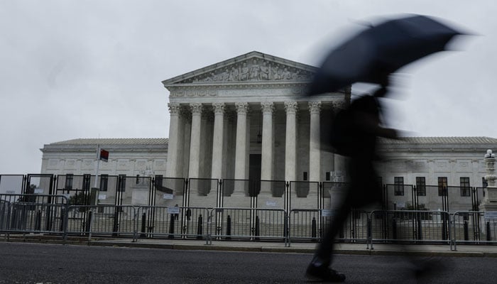 People walk past the U.S. Supreme Court Building during a rainstorm on June 23, 2022 in Washington, DC. Decisions are expected in 13 more cases before the end of the Courts current session. — AFP