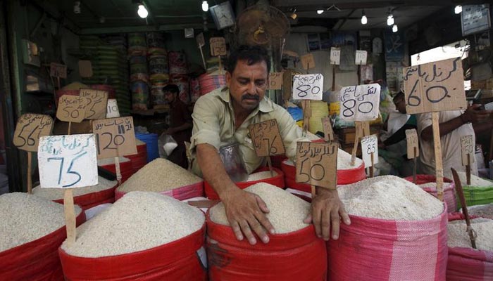 A shop owner can be seen fixing rates on commodities on rice bags. — Reuters/File