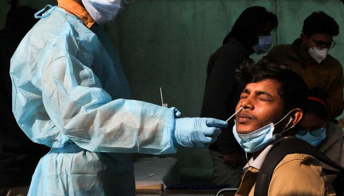 A health worker collects a coronavirus disease (COVID-19) test swab sample from a person, at a railway station in New Delhi, India, January 11, 2022.—Reuters