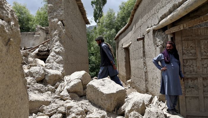 Afghan men stand on the debris of their house that was damaged by an earthquake in Gayan, Afghanistan, June 23, 2022. Picture taken June 23, 2022.—Reuters