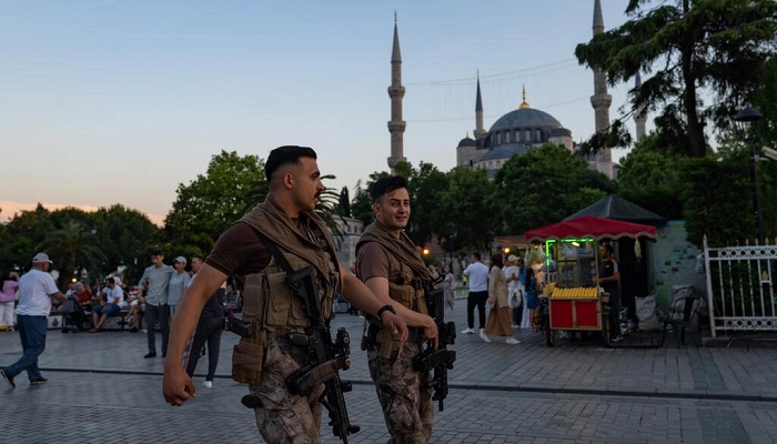 Turkish riot police officers walk in front of the Blue Mosque in Istanbul. — AFP