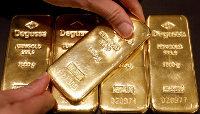 A person shows gold bars in this picture. — Reuters/File