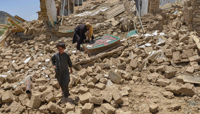 Afghan people look for their belongings amid the ruins of a house damaged by an earthquake in Bermal district, Paktika province, on June 23, 2022. Photo — Ahmad SAHEL ARMAN / AFP
