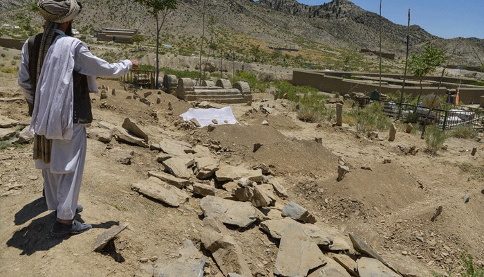 A villager looks over freshly dug graves containing victims of the deadly Afghan earthquake in Gayan district. — AFP