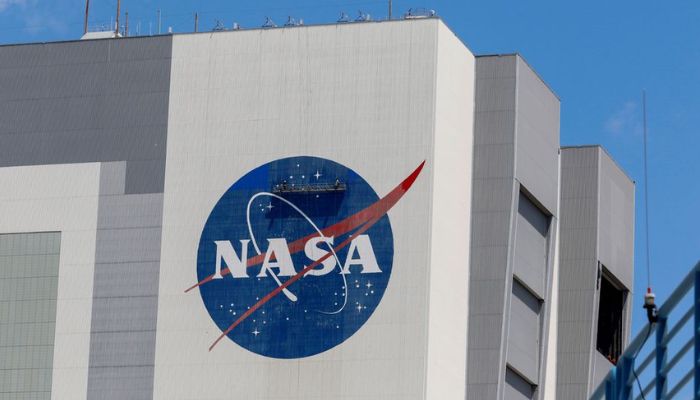 Workers pressure wash the logo of NASA on the Vehicle Assembly Building before SpaceX will send two NASA astronauts to the International Space Station aboard its Falcon 9 rocket, at the Kennedy Space Center in Cape Canaveral, Florida, US, May 19, 2020.