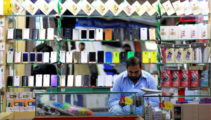 Shopkeeper sitting in a phone shop in phone market Islamabad. — Reuters
