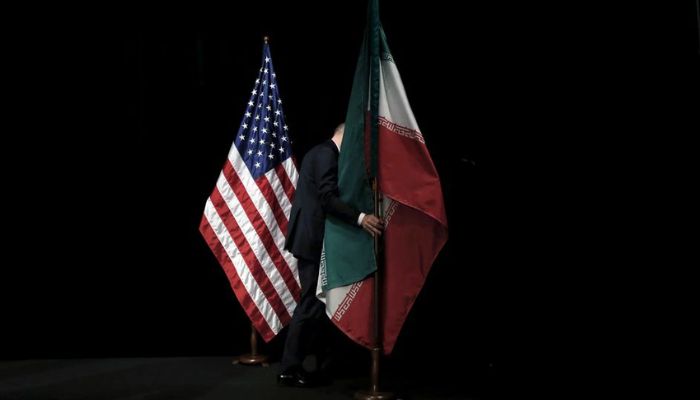 A staff member removes the Iranian flag from the stage after a group picture with foreign ministers and representatives of United States, Iran, China, Russia, Britain, Germany, France and the European Union during the Iran nuclear talks at the Vienna International Center in Vienna, Austria, July 14, 2015.—Reuters