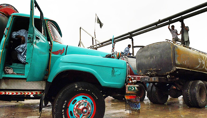 In this photograph taken on August 22, 2015, employees fill water tankers at a government hydrant to provide residential areas in Karachi. — AFP