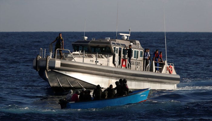 Migrants on a wooden boat are rescued by a patrol vessel of the Tunisia Navy, September 30, 2017. Photo—REUTERS/Darrin Zammit Lupi