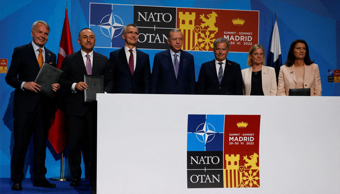 Turkish President Tayyip Erdogan, Finlands President Sauli Niinisto, Swedens Prime Minister Magdalena Andersson, NATO Secretary General Jens Stoltenberg, Turkish Foreign Minister Mevlut Cavusoglu Swedens Foreign Minister Ann Linde and Finnish Foreign Minister Pekka Haavisto pose after signing a document during a NATO summit in Madrid, Spain June 28, 2022.Photo— REUTERS/Yves Herman