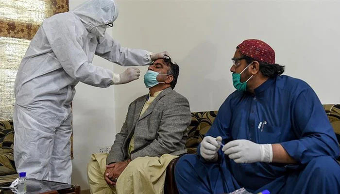 A paramedic takes a testing sample from a man during an earlier nationwide lockdown over the COVID-19 pandemic in Pakistan.— AFP