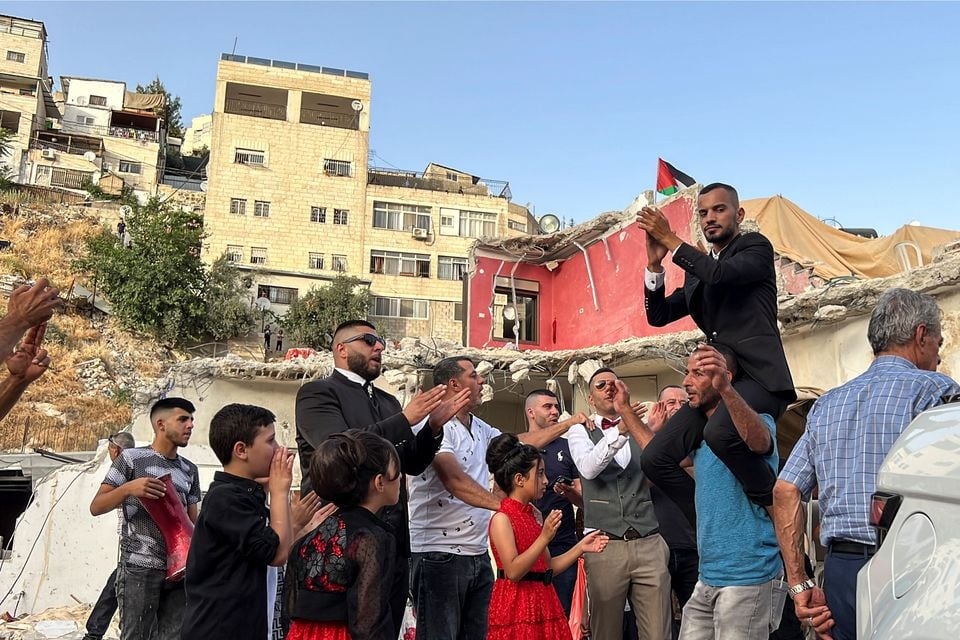 The groom of a Palestinian bride Rabeha Al-Rajabi, celebrates together with friends and family during a pre-wedding ceremony at Al-Rajabi house, that was partly demolished by Israel authority, in East Jerusalem June 11, 2022.—Reuters