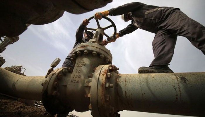 Two workers work on a gas pipeline. — AFP/File