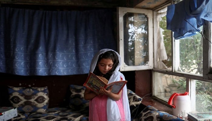 An Afghan girl reads a book inside her home in Kabul, Afghanistan, June 13, 2022.—Reuters