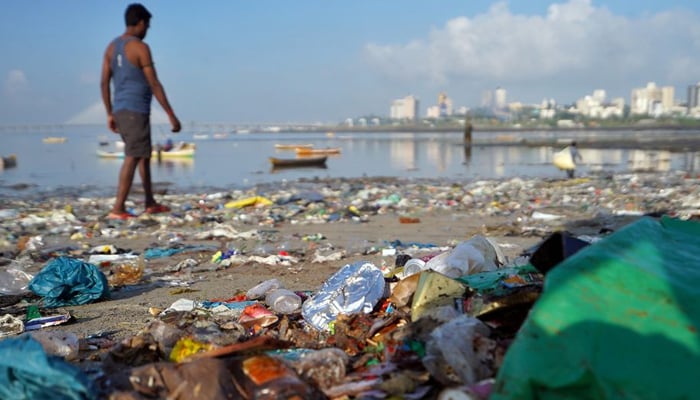 A man walks on a garbage-strewn beach in Mumbai, India, October 2, 2019.—Reuters