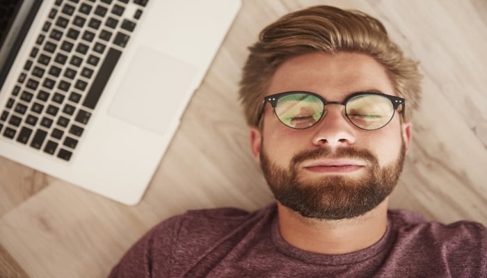 Image of a man sleeping next to his laptop. — Pixabay/Muntazar Mansory