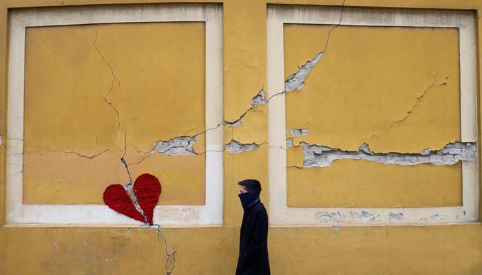 A man walks next to a repaired broken heart made of wool by Croatian designer Ivona on a building in downtown Zagreb, after an earthquake hit Croatia on March 22. — Reuters/File