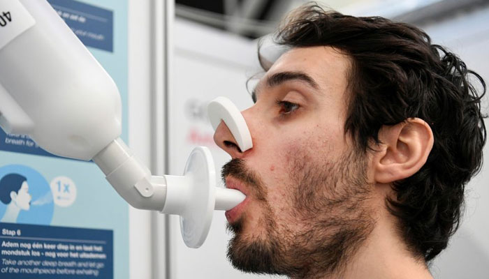 A man demonstrates how a Covid-19 breath test works as the coronavirus disease (COVID-19) testing facilities in the Netherlands will in the coming months be equipped with breath tests capable of giving immediate results, to speed up testing and make it less intrusive in Amsterdam, Netherlands February 1, 2021. Picture taken February 1, 2021.—Reuters