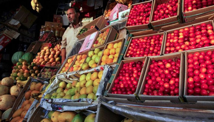 A man sells fruit from his stall along a road in Srinagar June 23, 2011. — Reuters/File