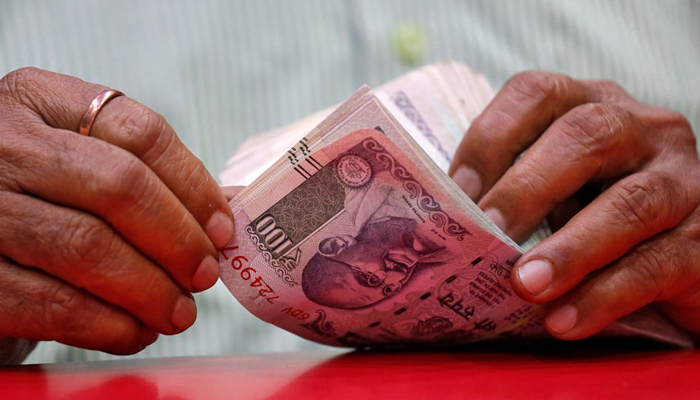 A man counts Indian currency notes inside a shop in Mumbai, India, on August 13, 2018. — Reuters