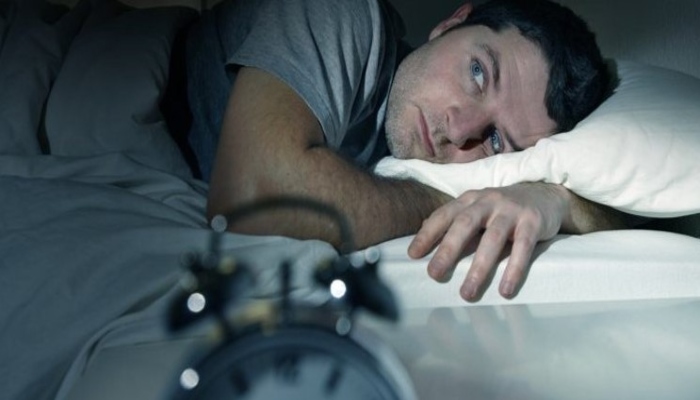 Man looking away from the camera as he lies in bed. — Reuters