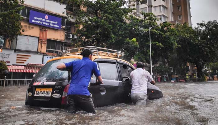 People and vehicles get stuck in water after the monsoon.— Unsplash