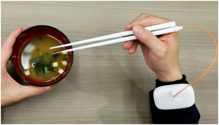 An employee of Kirin Holdings demonstrates chopsticks that can enhance food taste using an electrical stimulation waveform that was jointly developed by the company and Meiji Universitys School of Science and Technology Professor Homei Miyashita, in Tokyo, Japan April 15, 2022. — Reuters/ Issei Kato