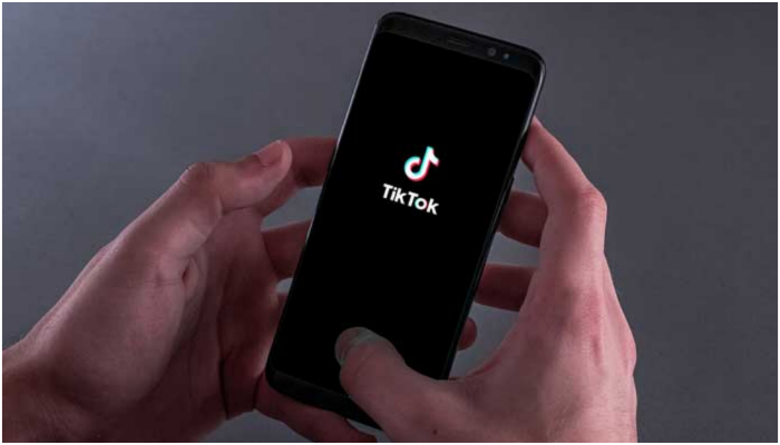 Image showing a person holding a cellular phone with the logo of TikTok seen on the screen. — Ugo Padovani/Hans Lucas/Reuters