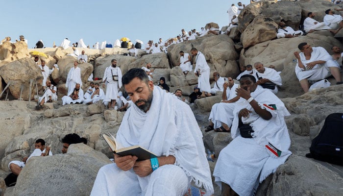Man recites Quran whil sitting atop of Mount Arafat. — Reuters